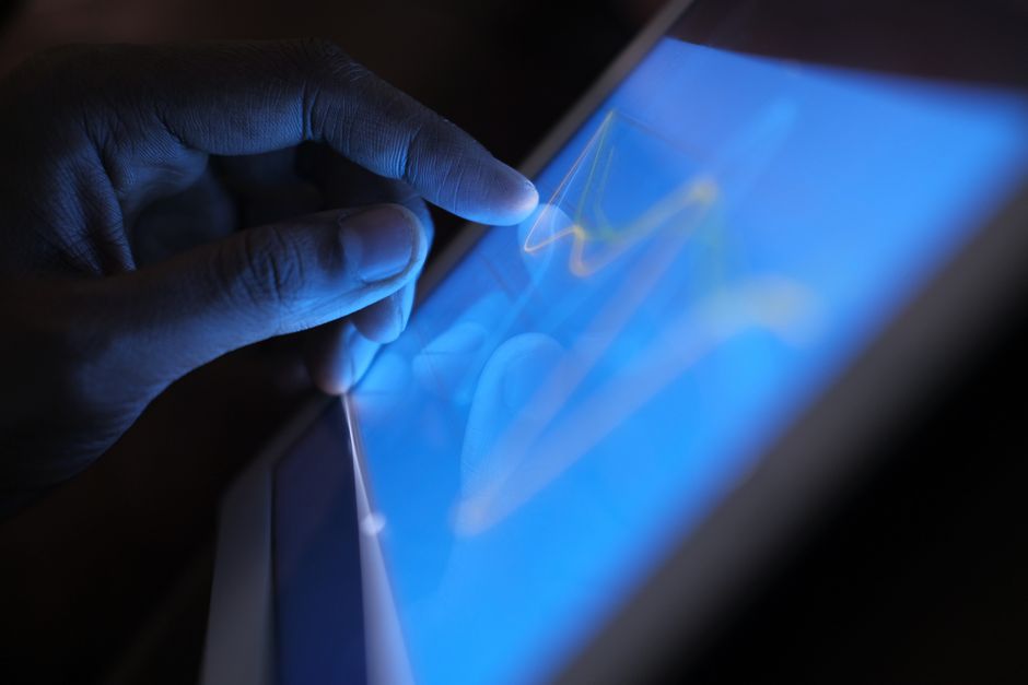 A forward-thinking professional interacting with a glowing, transparent digital interface in a dark, modern setting, representing the AI-first search era.
